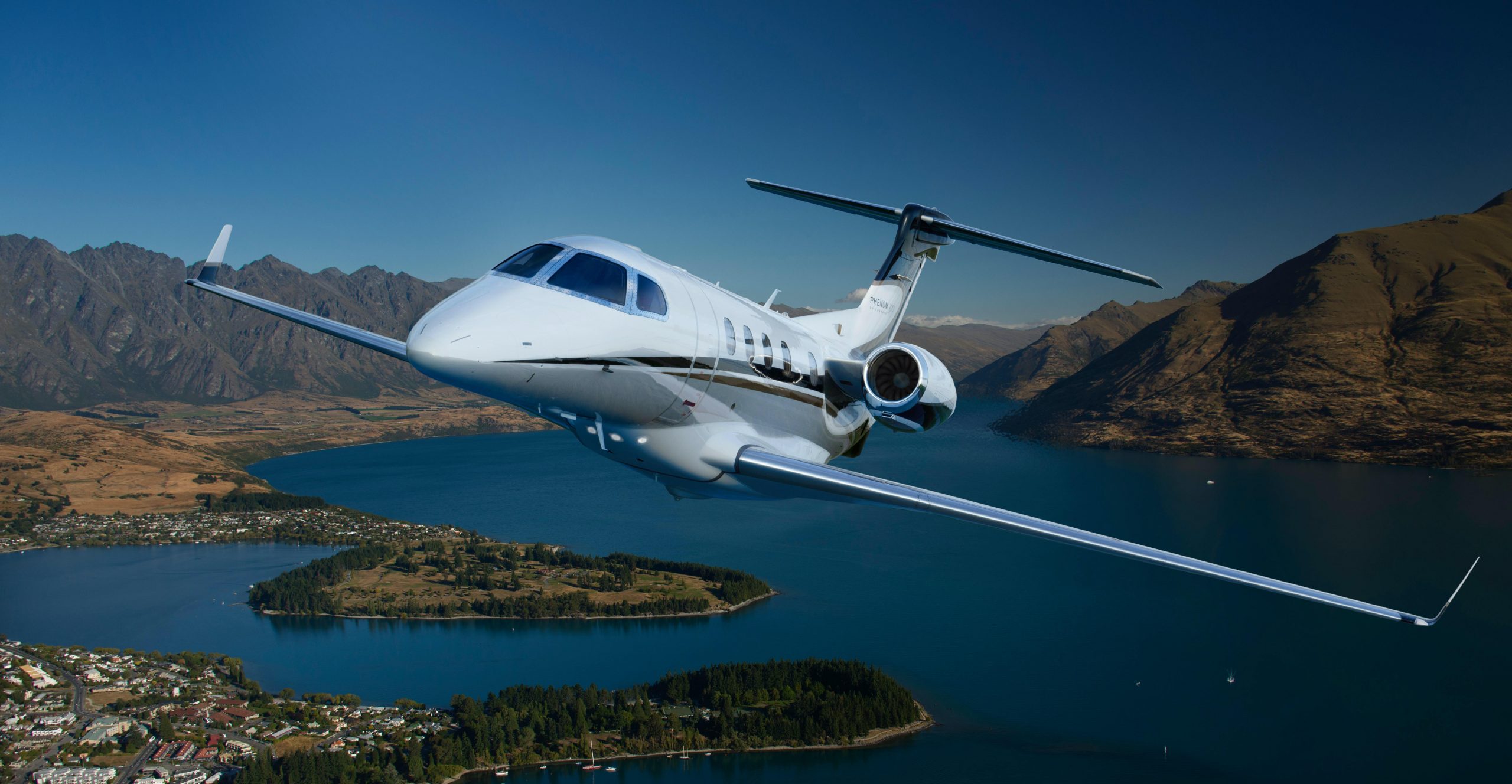 business jet flying above mountains