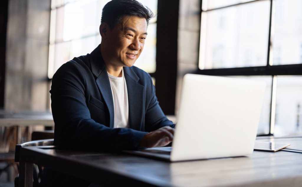 asian businessman typing on laptop