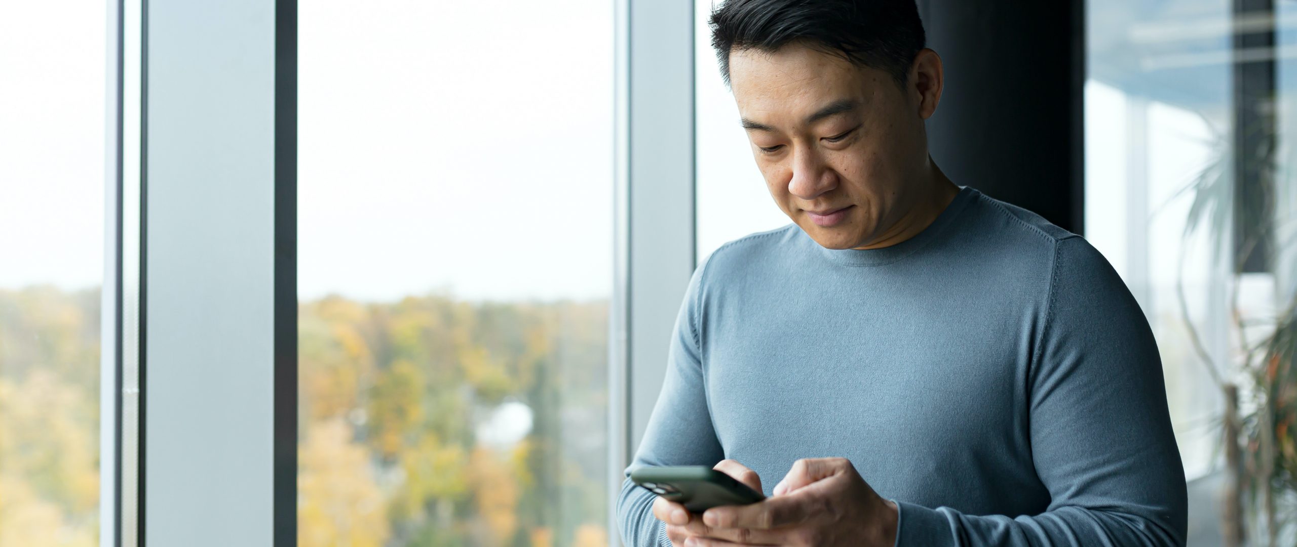 asian business man scrolling on phone