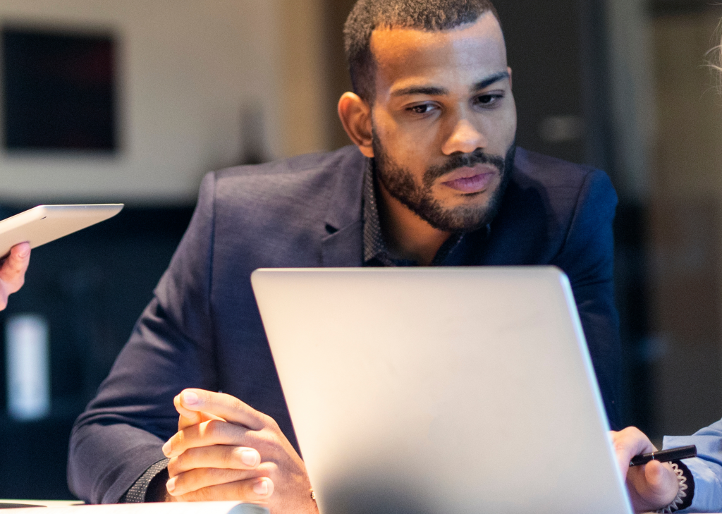 young man in a suit looking at laptop